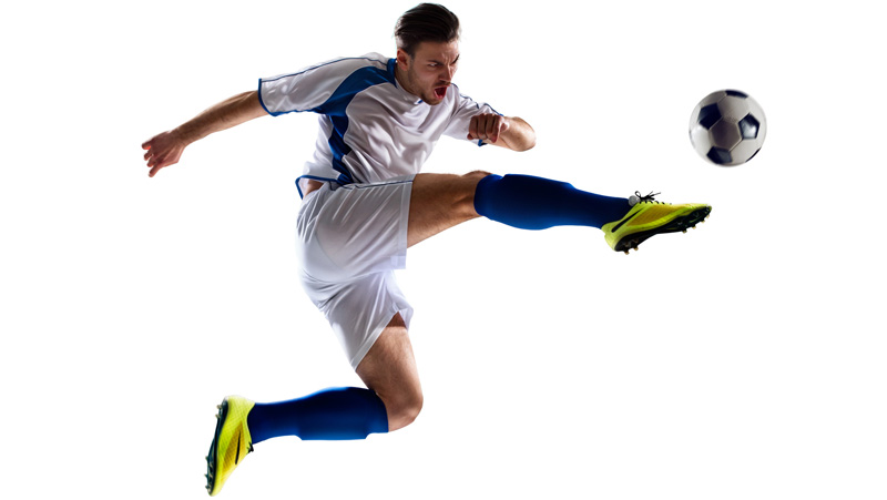 Soccer player kicking the ball in mid air